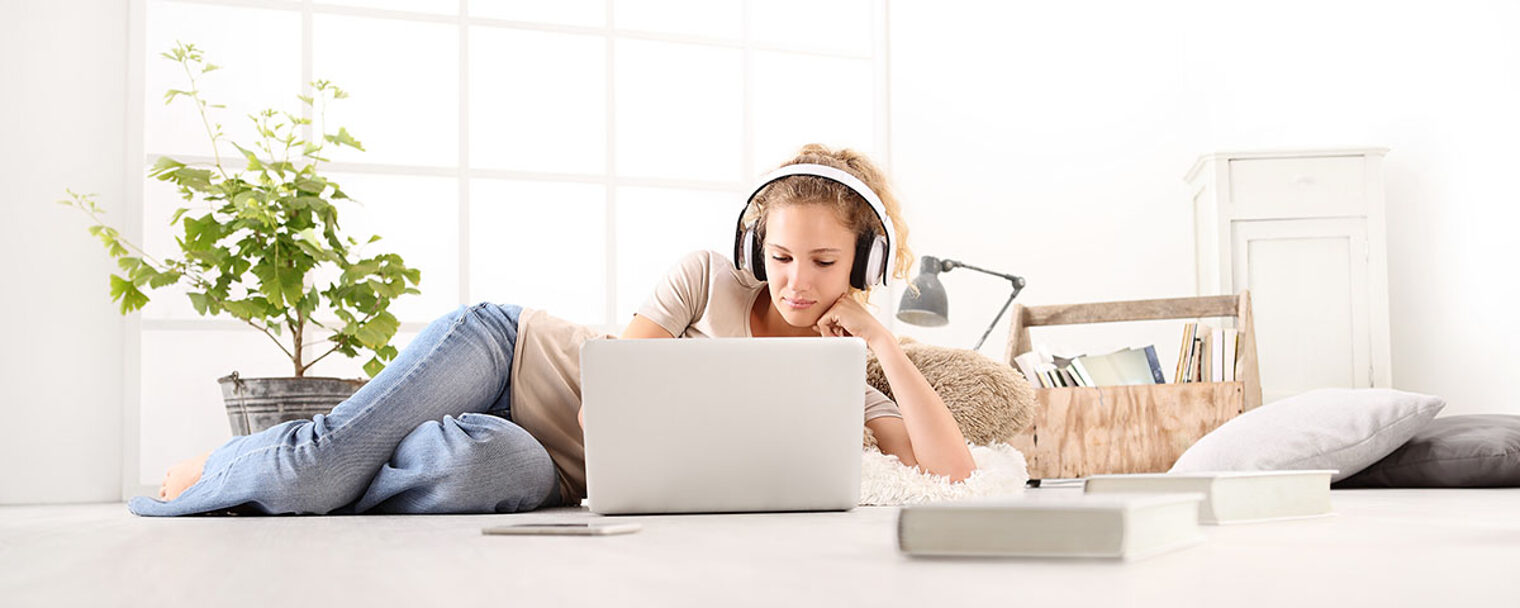 young woman with computer, headphones, smartphone and books, lying on the floor in living room on white wide window in the background Schlagwort(e): woman, home, music, computer, headphones, laptop, young, using, living, room, lying, student, listening, internet, lifestyle, learning, education, online, smart, phone, modern, creative, indoors, tutorial, casual, technology, looking, studying, floor, teenager, notebook, web, wireless, girl, vocal, device, app, social, thoughtful, white, youth, books, video, message, send, receive, chat, blog, reading, communication