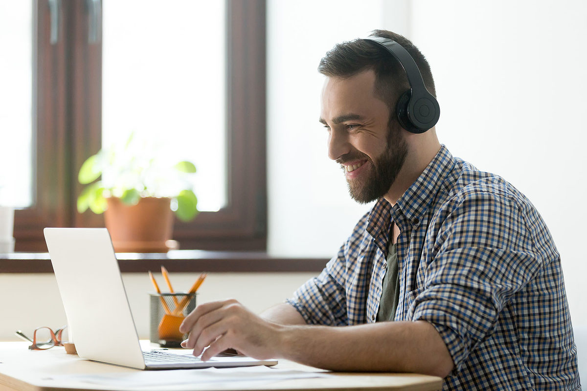 Handsome man with beard listening music in headphones and looking on screen of laptop. Young manager having a rest and playing in computer games or making video call on pc Schlagwort(e): beard, break, business, businessman, career, casual, cheerful, communication, computer, concept, device, emotional, employee, enjoy, freelance, games, glad, happy, headphones, headset, hipster, home, job, learning, lifestyle, listen, male, man, manager, millennial, music, office, online, people, person, pleasure, positive, project, satisfaction, satisfied, sitting, skype, smile, success, successful, typing, webinar, work, worker, young
