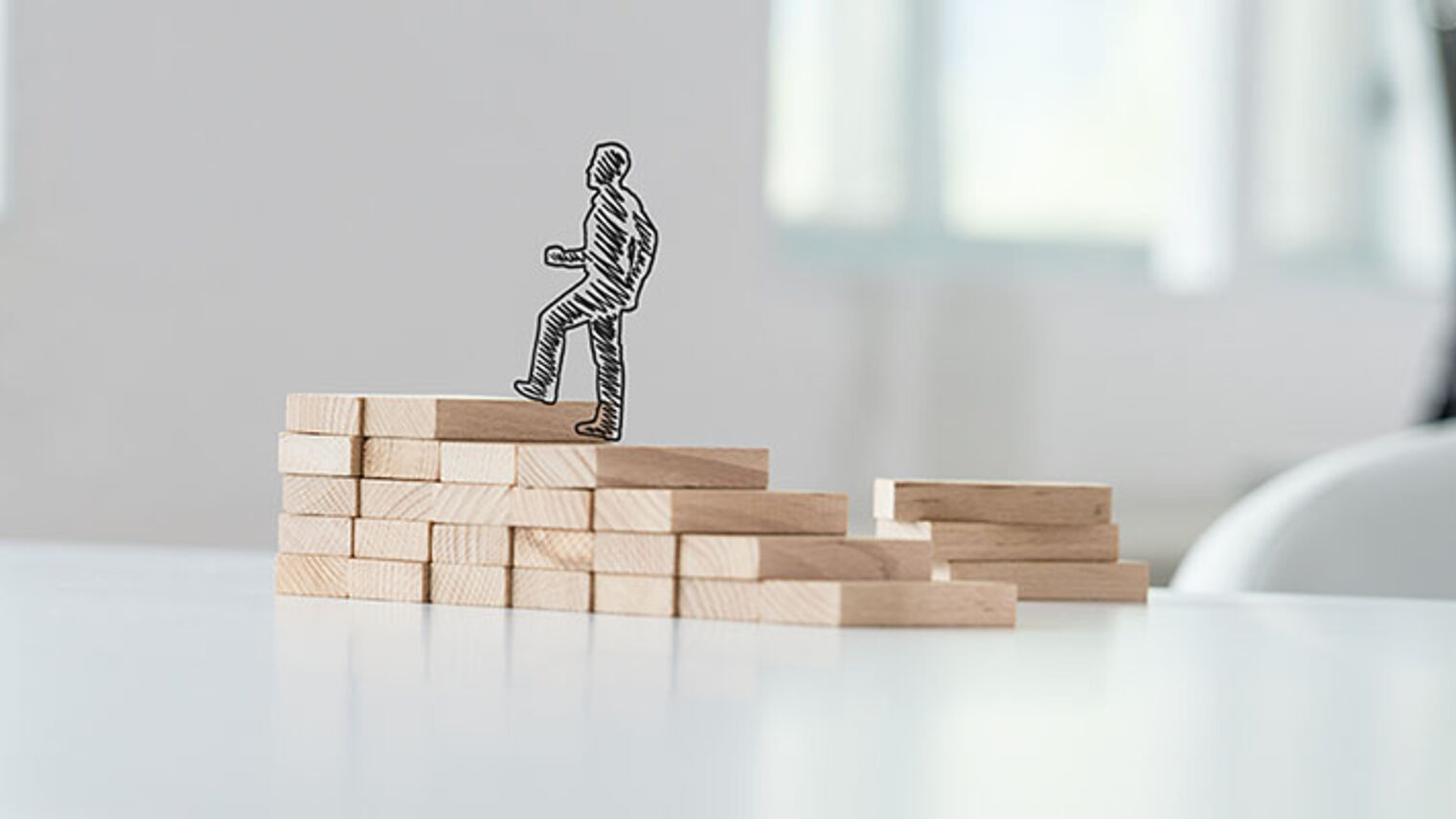 Wide view image of hand drawn silhouette of a businessman climbing up the steps made of wooden pegs on a business office desk. Schlagwort(e): promotion, ambition, education, business, career, upward, success, up, moving, businessman, stairs, step, achievement, development, progress, climbing, growth, walking, climb, successful, professional, confident, opportunity, challenge, grow, forward, graduation, effort, improvement, determination, motivation, life, strategy, direction, associate, knowledge, advance, breakthrough, process, aspiration, personal, wide, view, wooden, steps, stairway, concept, silhouette, office, desk, drawn